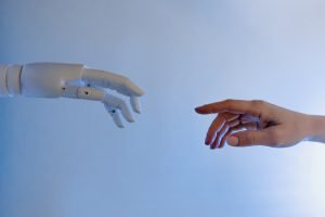 imagem com uma mão robotica e uma mão humana expressando o usao de ia e as diretrizes do google